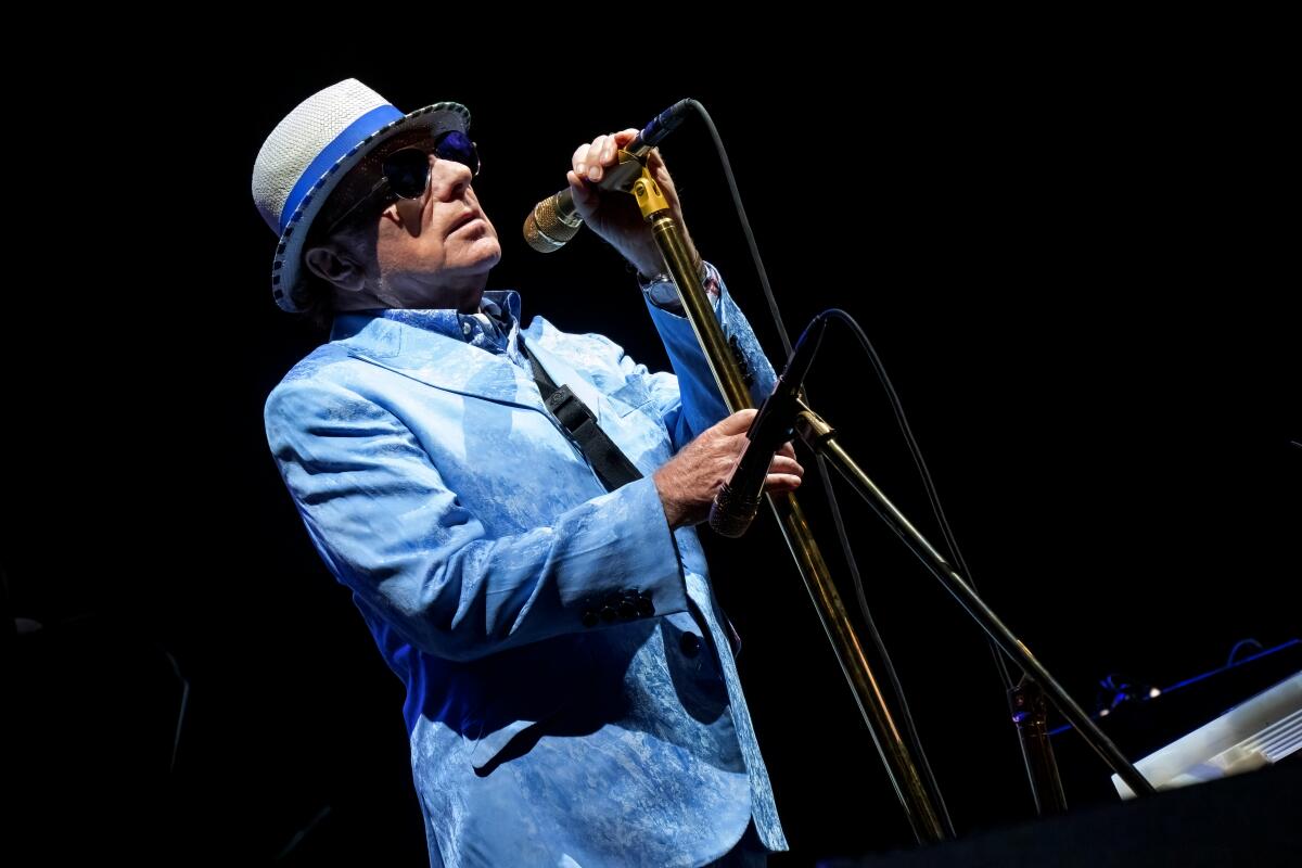 Van Morrison performing in a blue suit and hat.