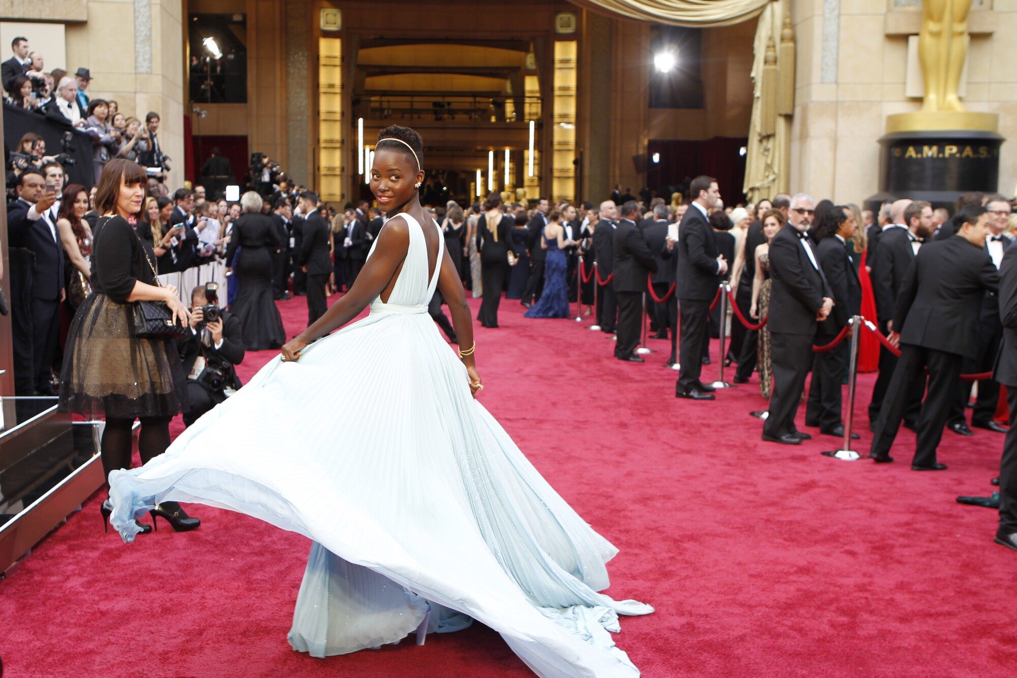 Lupita Nyong'o shows off her dress at the 86th Academy Awards. 