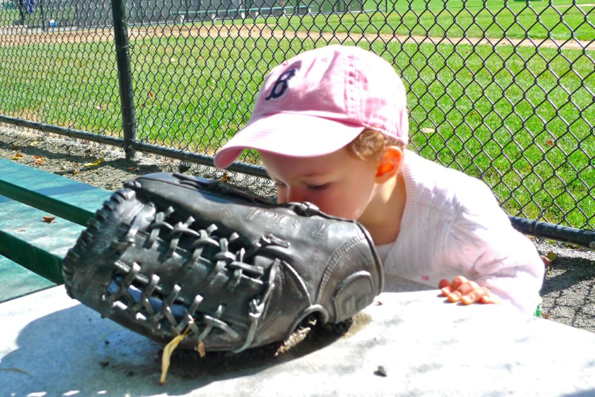 Rowena Lucas, daughter of Teddy Ebersol's sister, Sunshine Lucas, kisses the glove in memory of Teddy.