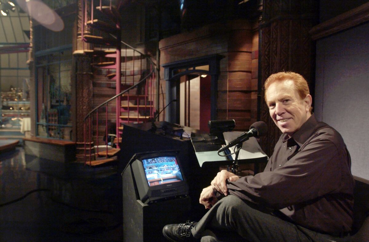 FILE - In this Nov. 20, 2003, file photo, "Late Show With David Letterman'' announcer Alan Kalter poses in the the Late Show studio in New York. Kalter, the quirky, red-headed announcer for David Letterman for two decades who frequently appeared in the show's comedy bits, has died Monday, Oct. 4, 2021, at Stamford Hospital in Connecticut. He was 78. (Andrew Sullivan/Hearst Connecticut Media via AP, File)