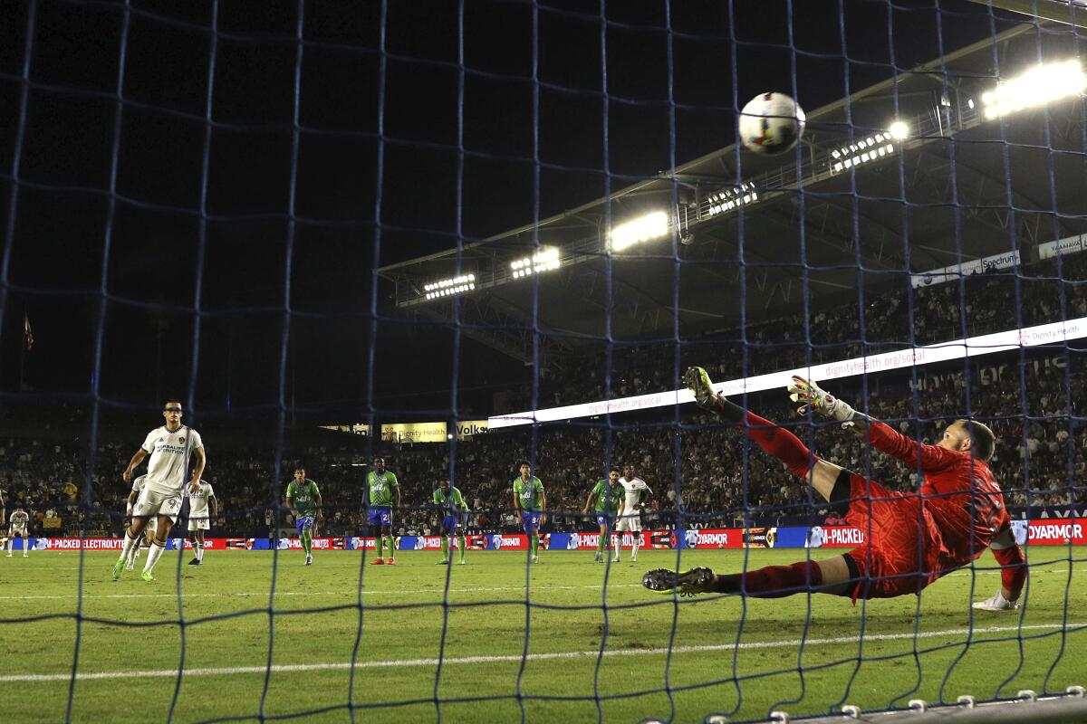 The Galaxy's Dejan Joveljic, left, scores on a penalty kick against Sounders goalkeeper Stefan Frei on Aug. 19, 2022.