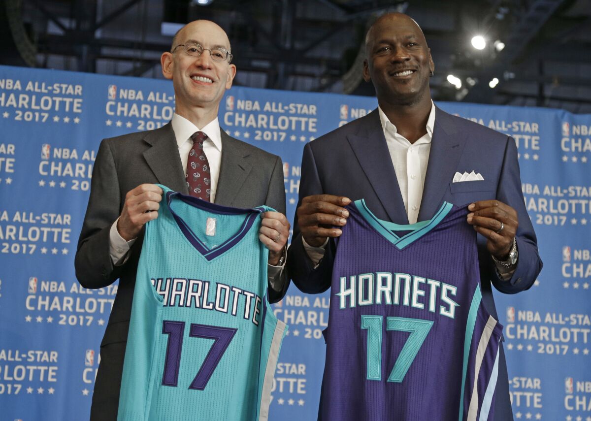 ARCHIVO - El comisionado de la NBA Adam Silver (izquierda) y el dueño de los Hornets de Charlotte Michael Jordan posan durante el anuncio de Charlotte como sede del Juego de Estrellas de la NBA, el 23 de junio de 2015. (AP Foto/Chuck Burton)