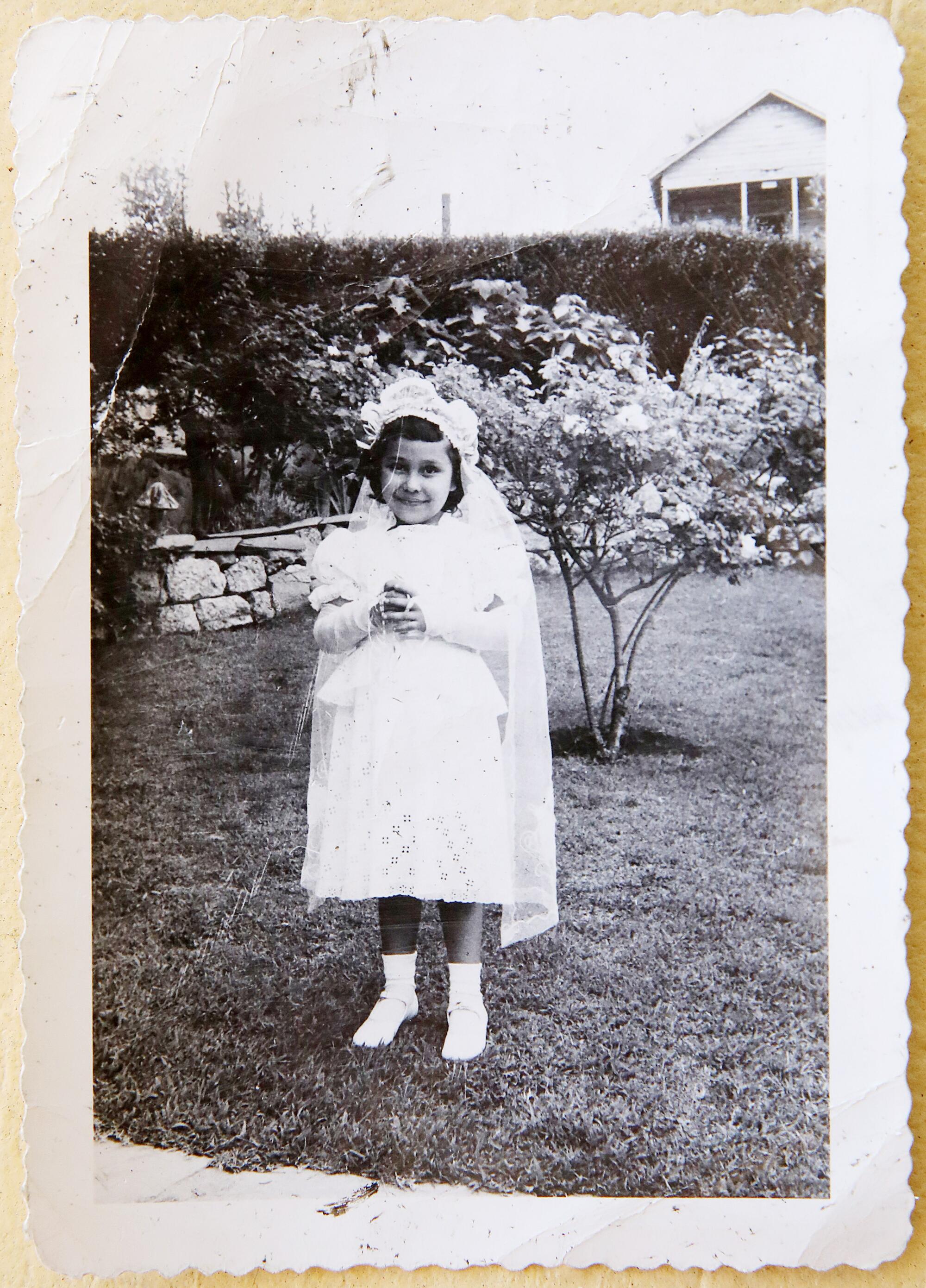 Carol Jacques, de 6 aos, en el día de su primera comunión, en el patio de su casa en Chavez Ravine.