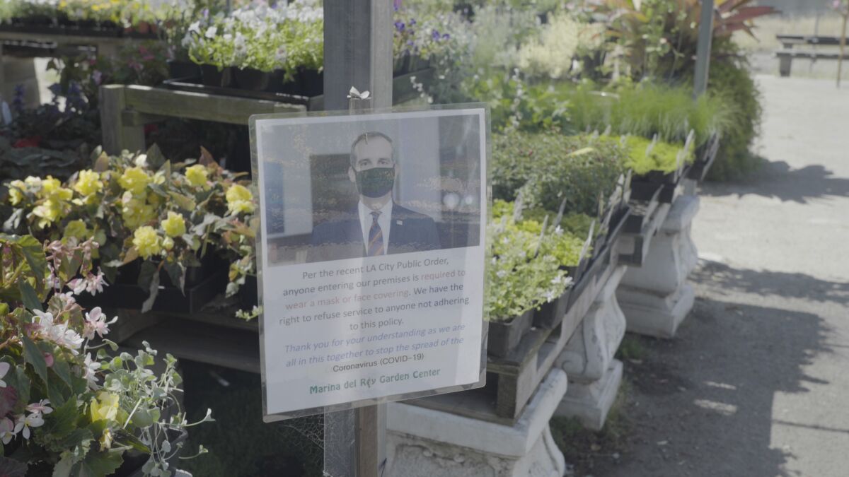 A sign with Mayor Eric Garcetti in a black mask says customers must wear face coverings at the Marina del Rey Garden Center.