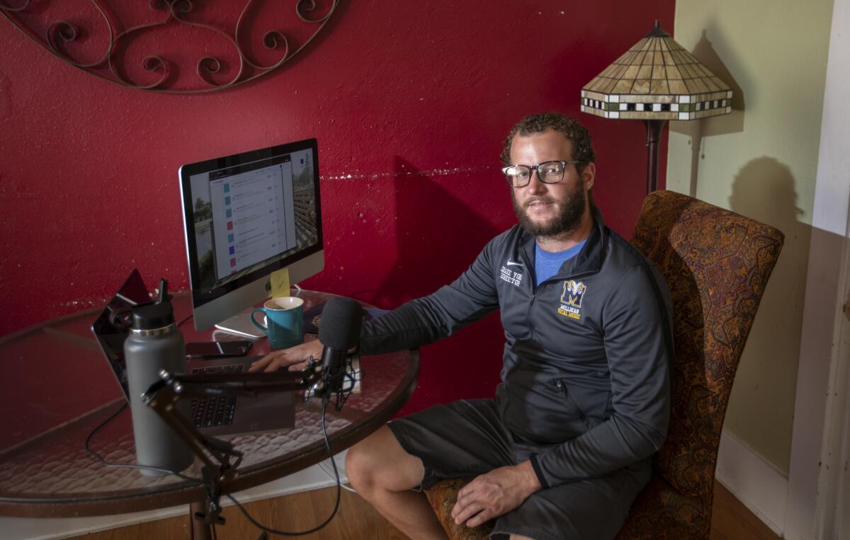 A man sits at his home computer setup