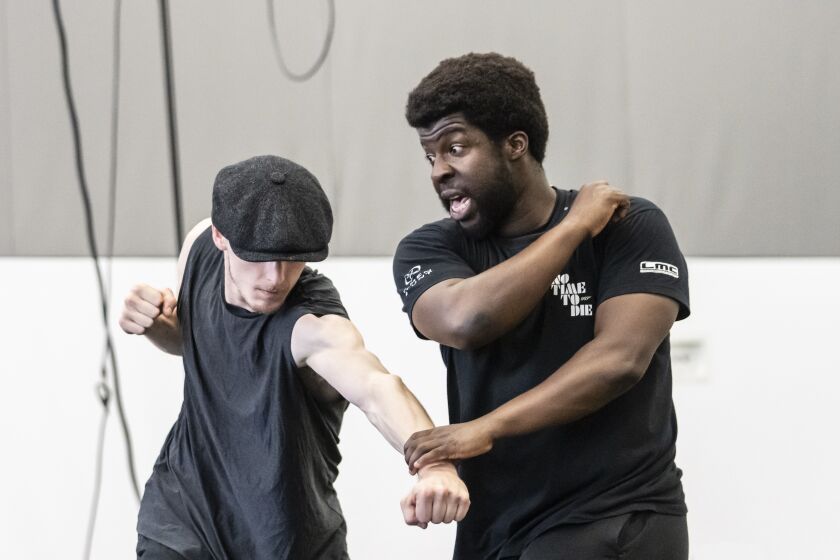 This image released by Rambert Dance shows Conor Kerrigan, left, with fight director Adrian Palmer during a rehearsal for the dance production "Peaky Blinders: The Redemption of Thomas Shelby," in London, England. The production, based on the popular series "Peaky Blinders," a 1920′s gangster drama set in Birmingham, England. (Johan Persson/Rambert Dance via AP)