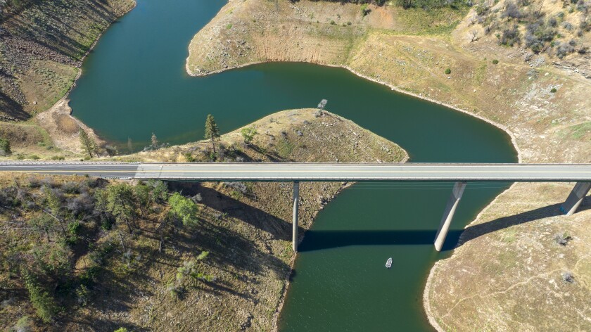 Aerial view of a bridge going over a reservoir with low water levels