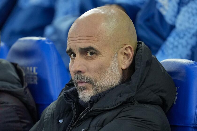 Manchester City's head coach Pep Guardiola looks out from the bench prior the English Premier League soccer match between Brighton and Manchester City at the Falmer Stadium in Brighton, England, Thursday, April 25, 2024. (AP Photo/Kin Cheung)