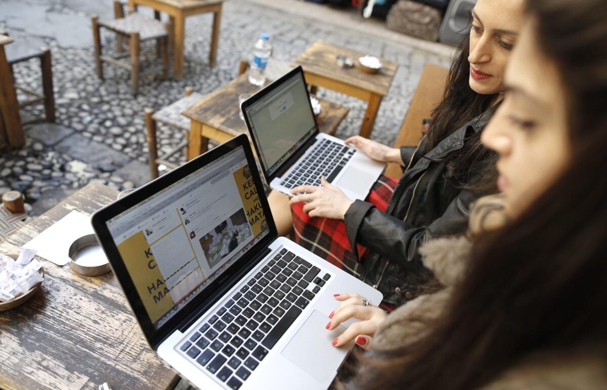 Two Turkish women try to connect to the blocked Twitter site at an Istanbul cafe.