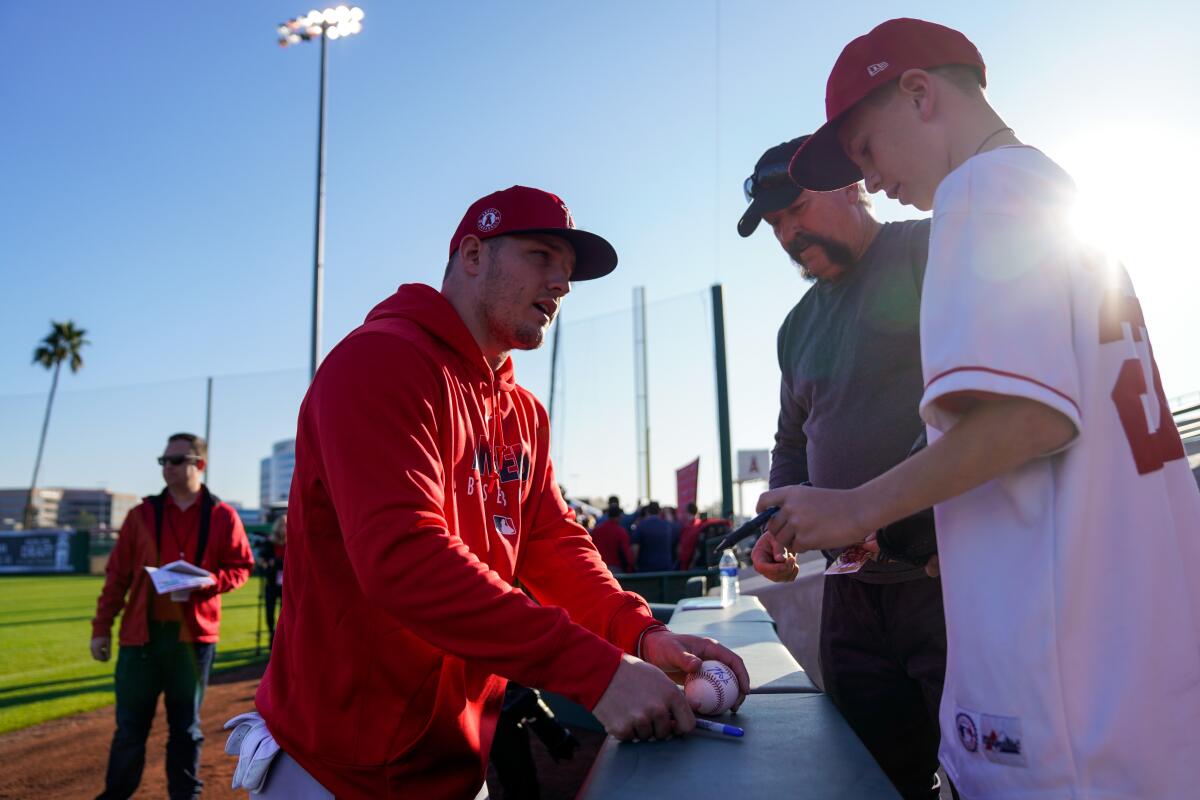 The Angels' Mike Trout signs a ball for fans at Tempe Diablo Stadium in Tempe, Ariz.  