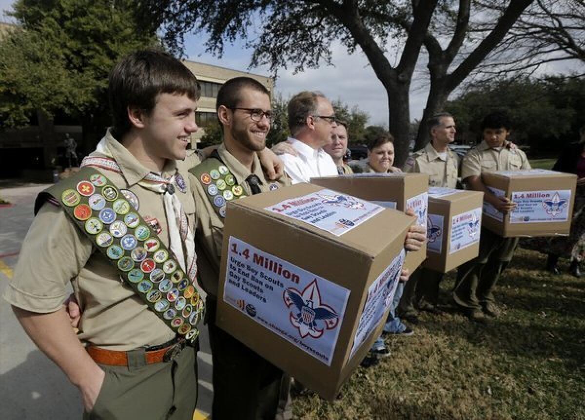 James Oliver, left, hugs his brother and fellow Eagle Scout, Will Oliver, who is gay, as Will and other supporters carry four boxes filled with a petition in front of the Boy Scouts of America headquarters in Dallas. Boy Scout officials are surveying adult members about their attitudes on gay membership, which will be voted on in late spring.