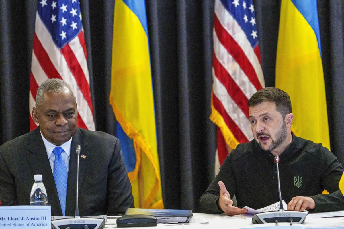 Lloyd J. Austin III sits next to Volodymyr Zelensky.