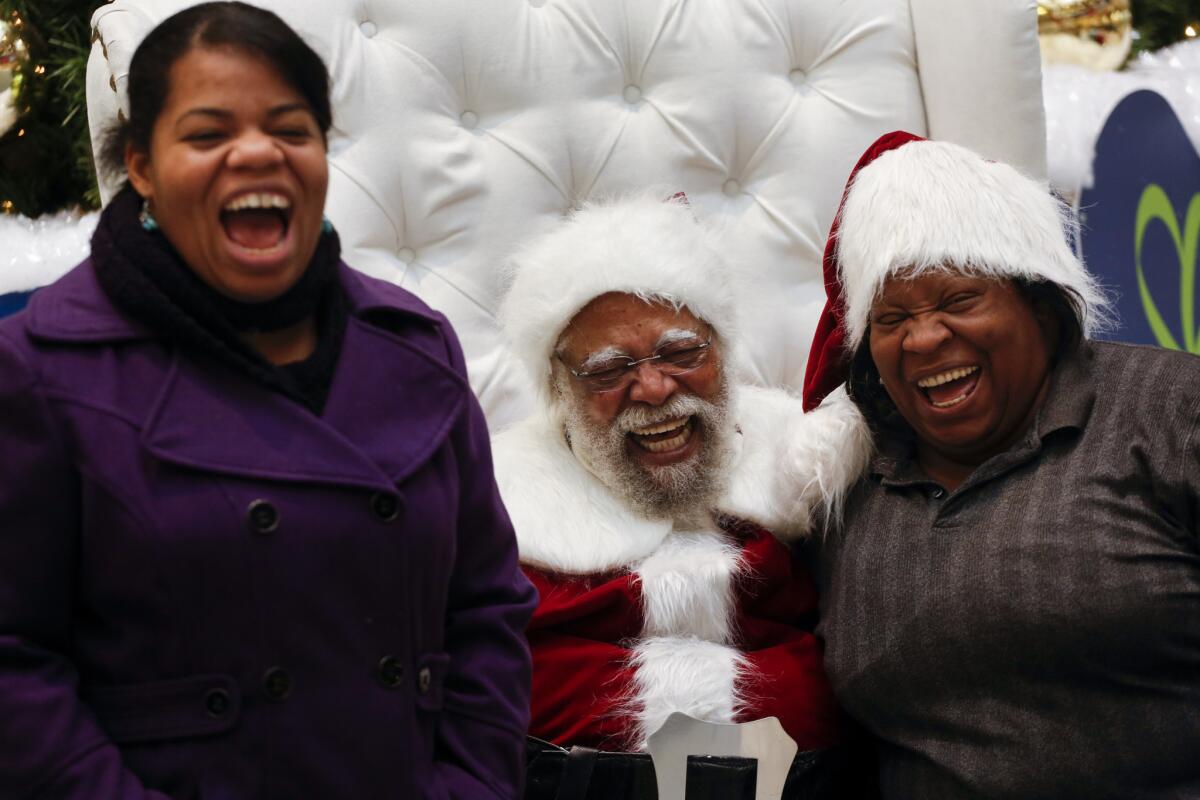 Kelly Ross, left, and her mom, Tracy Price, share a big laugh with Santa at the Baldwin Hills Crenshaw Plaza on Dec. 7, 2013.