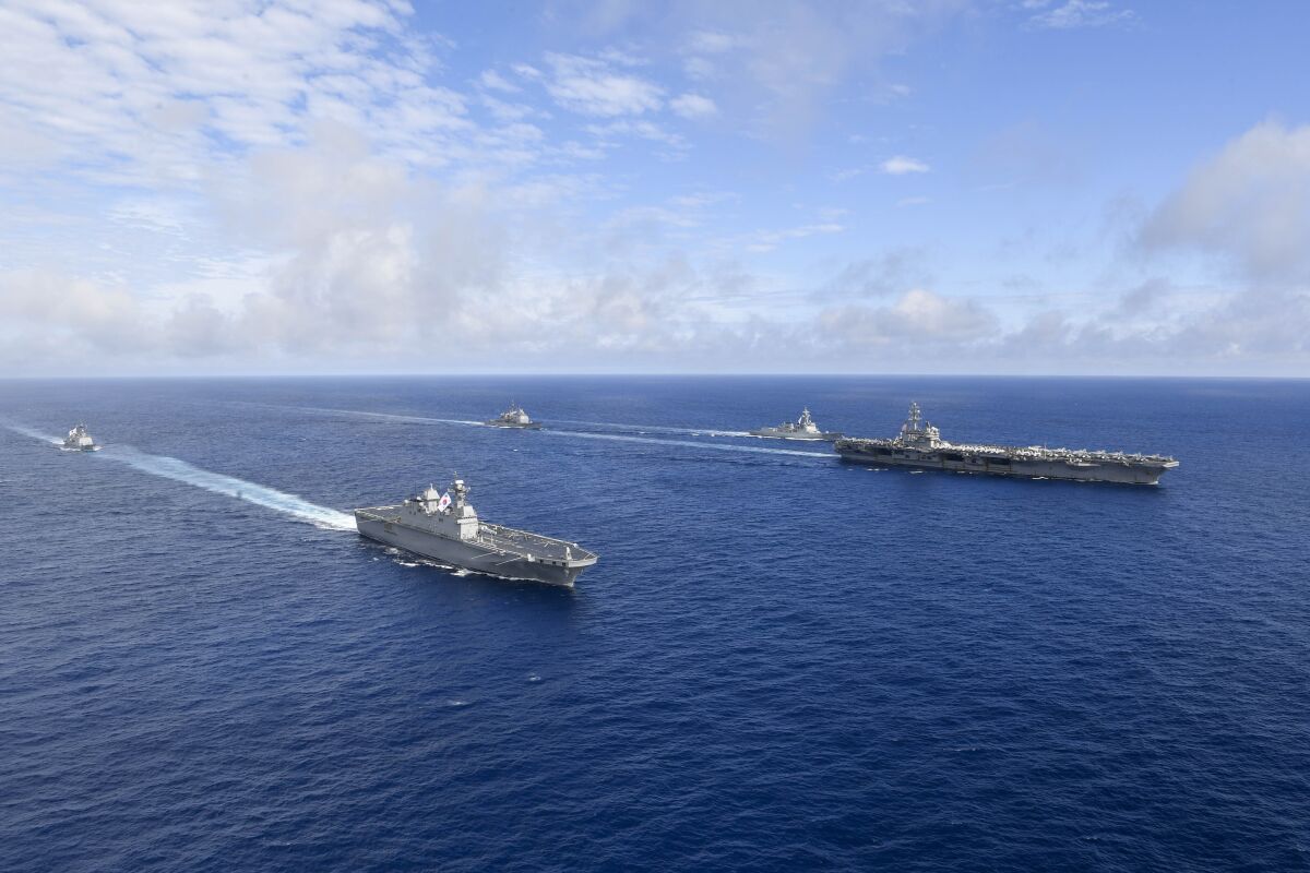 In this photo provided by South Korea's Defense Ministry, U.S. nuclear-powered aircraft carrier USS Ronald Reagan, right, and South Korea's landing platform helicopter (LPH) ship Marado, second from left, sail during a joint military exercise at an undisclosed location, Saturday, June 4, 2022. (South Korea Defense Ministry via AP)