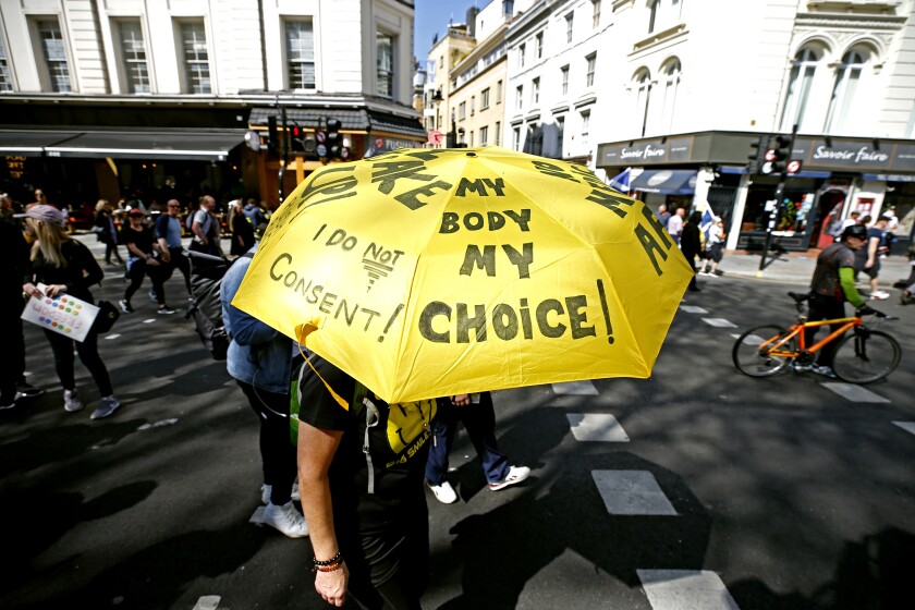 A protester's umbrella says 'my body, my choice.'