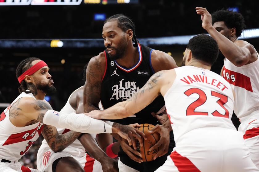 Los Angeles Clippers forward Kawhi Leonard tries to keep the ball from Toronto Raptors guard Gary Trent Jr., left, and guard Fred VanVleet (23) during the first half of an NBA basketball game Tuesday, Dec. 27, 2022, in Toronto. (Frank Gunn/The Canadian Press via AP)