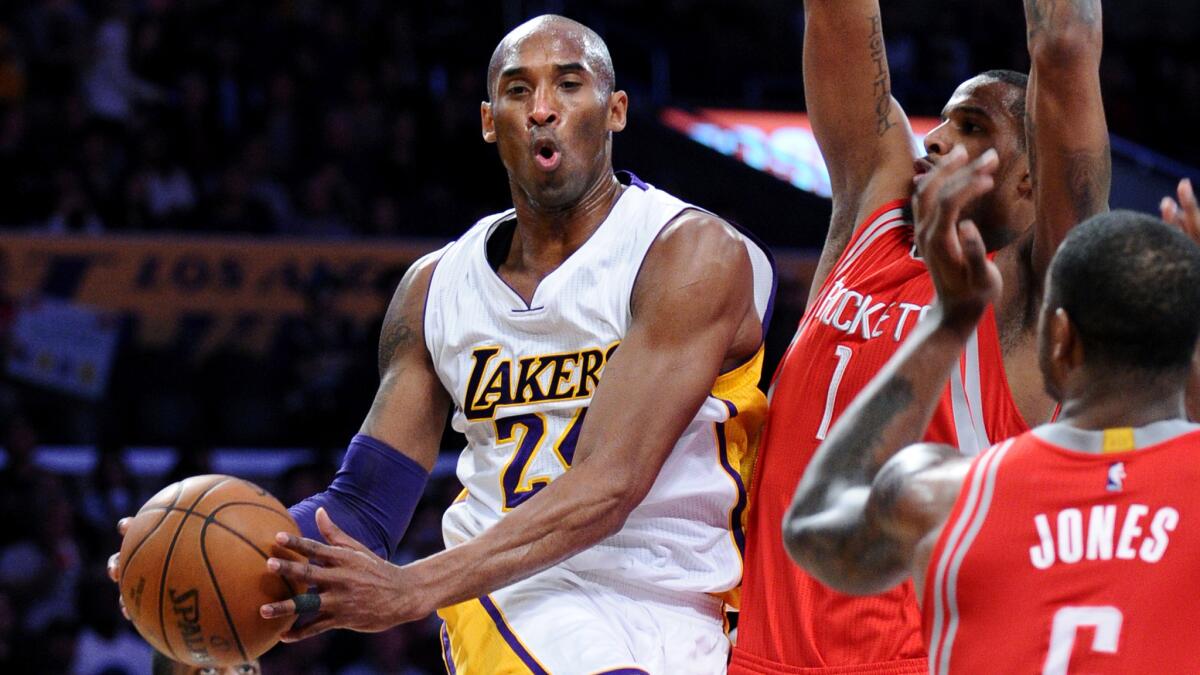Lakers forward Kobe Bryant looks to pass after driving to the basket against the Rockets in the first half.