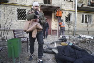 An injured man walks past a body of a man who was killed by a Russian strike in Kharkiv, Ukraine, Wednesday, March 27, 2024. (AP Photo/Andrii Marienko)