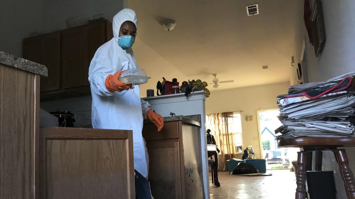 Corinth Williams, 28, discards kitchenware as she helps clean out her grandmother's house in Port Arthur.