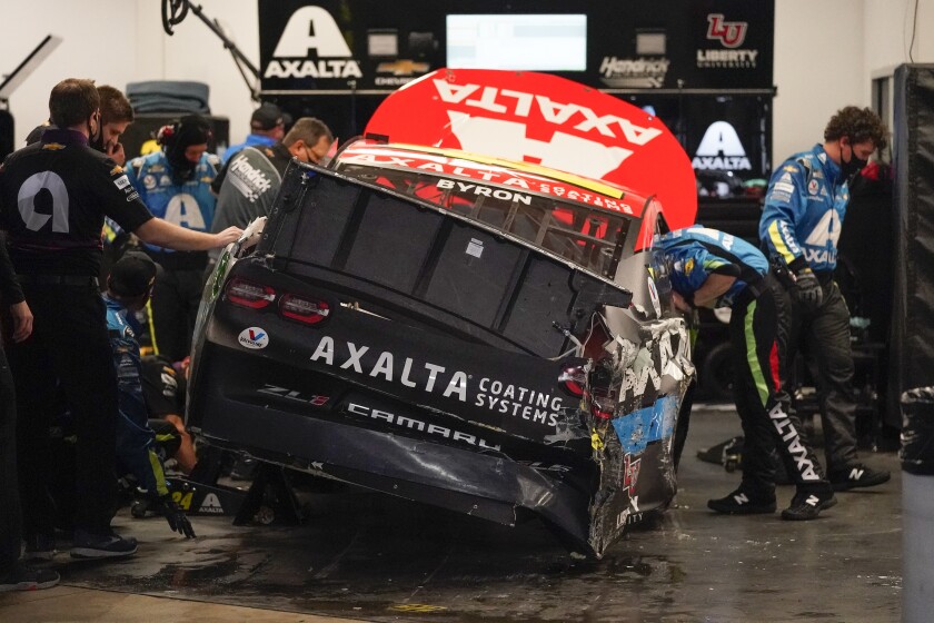 Crew members work on William Byron's car after he wrecked in the second of two qualifying auto races for the NASCAR Daytona 500 at Daytona International Speedway, early Friday, Feb. 12, 2021, in Daytona Beach, Fla. (AP Photo/John Raoux)