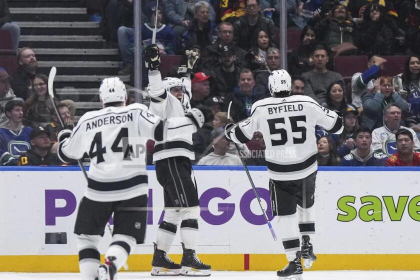 Los Angeles Kings' Anze Kopitar, center, Quinton Byfield (55) and Mikey Anderson (44) celebrate Kopitar's goal