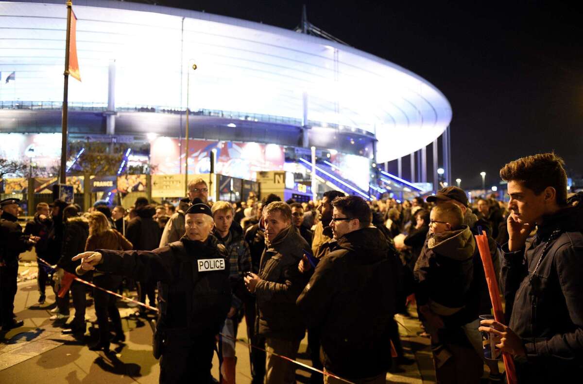 Un policía da instrucciones a fans afuera del Stade de France, surante el amitoso Francia vs Alemania, en Saint-Denis, al norte de París.