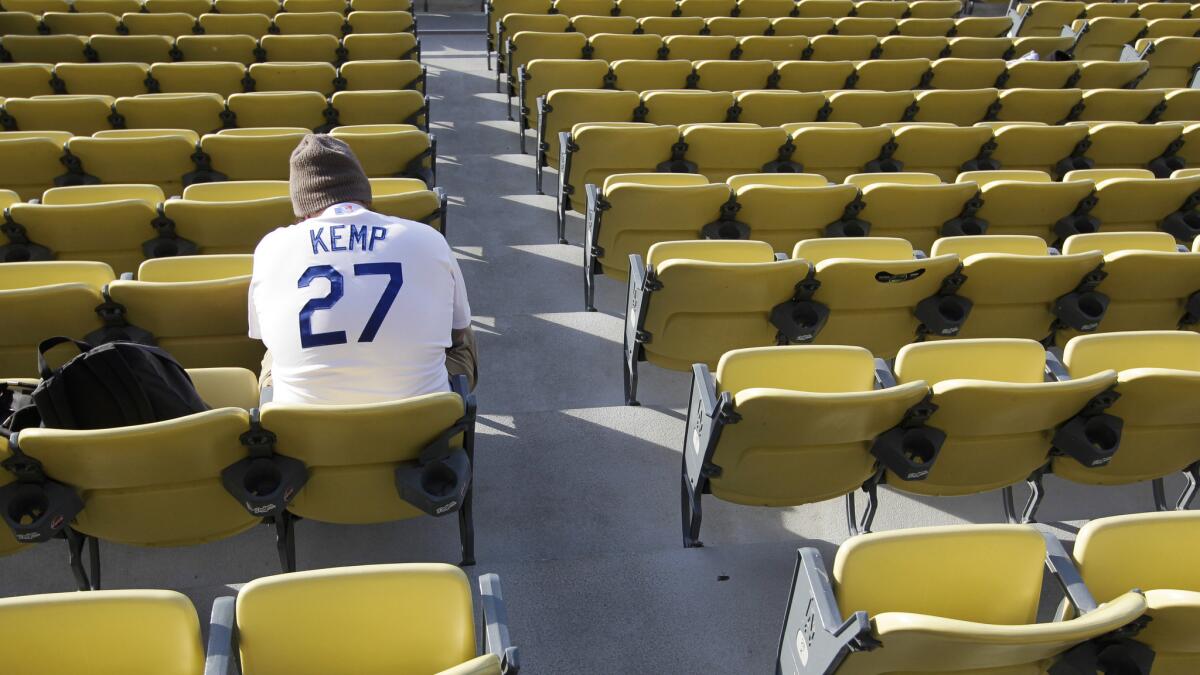 A Dodgers fan wearing a Matt Kemp jersey sits in the field level section of Dodger Stadium before a game against the Philadelphia Phillies. The limited availability of Dodgers games on television due to the team's broadcast contract with Time Warner Cable has left many fans frustrated.