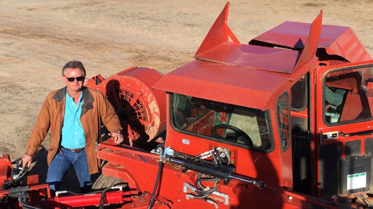 Kevin Herman with one of the three new almond sweepers he bought for his farm near Madera, Calif., to reduce the number of seasonal field workers he'll need.