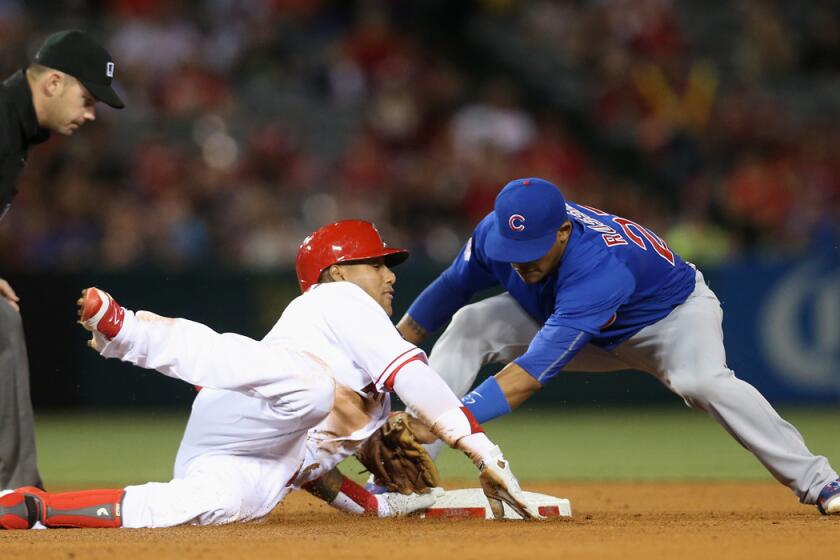 Angels' Yunel Escobar, left, slides into second with a double ahead of the tag by Chicago Cubs second baseman Addison Russell in the sixth inning at Angel Stadium on Tuesday.