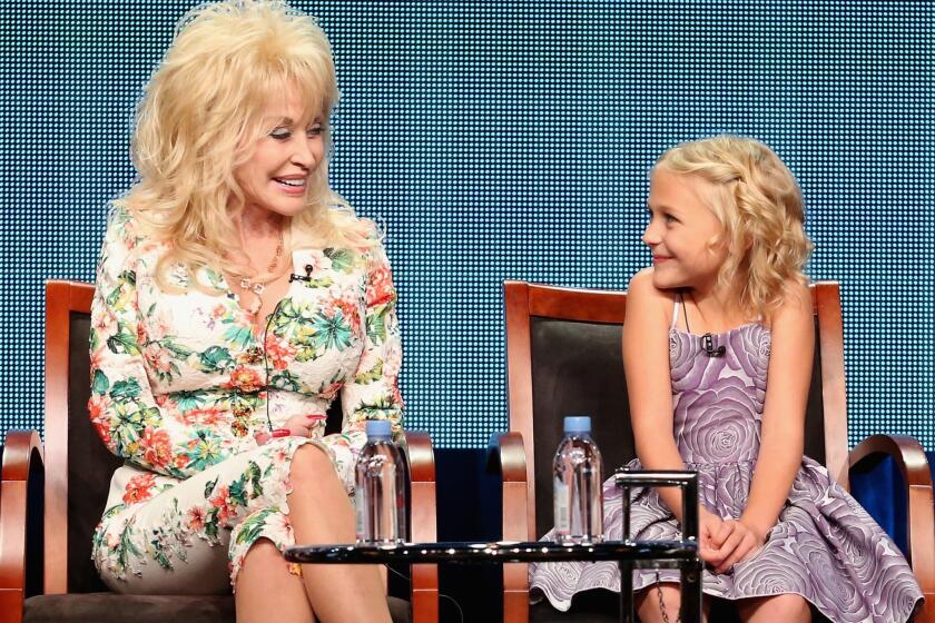 Executive producer Dolly Parton and actress Alyvia Lind speak onstage during NBC's 'Dolly Parton's Coat of Many Colors' panel discussion at the NBCUniversal portion of the TCA summer press tour at the Beverly Hilton.