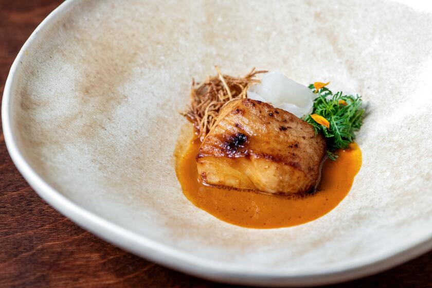 LOS ANGELES, CA - OCTOBER 11: From the DAE course, "sometimes nomadic": soy-braised wild black cod with lemongrass buttermilk sauce, chamoe dongchimi, fried green papaya, citrus fern from Baroo on Wednesday, Oct. 11, 2023 in Los Angeles, CA. (Mariah Tauger / Los Angeles Times)