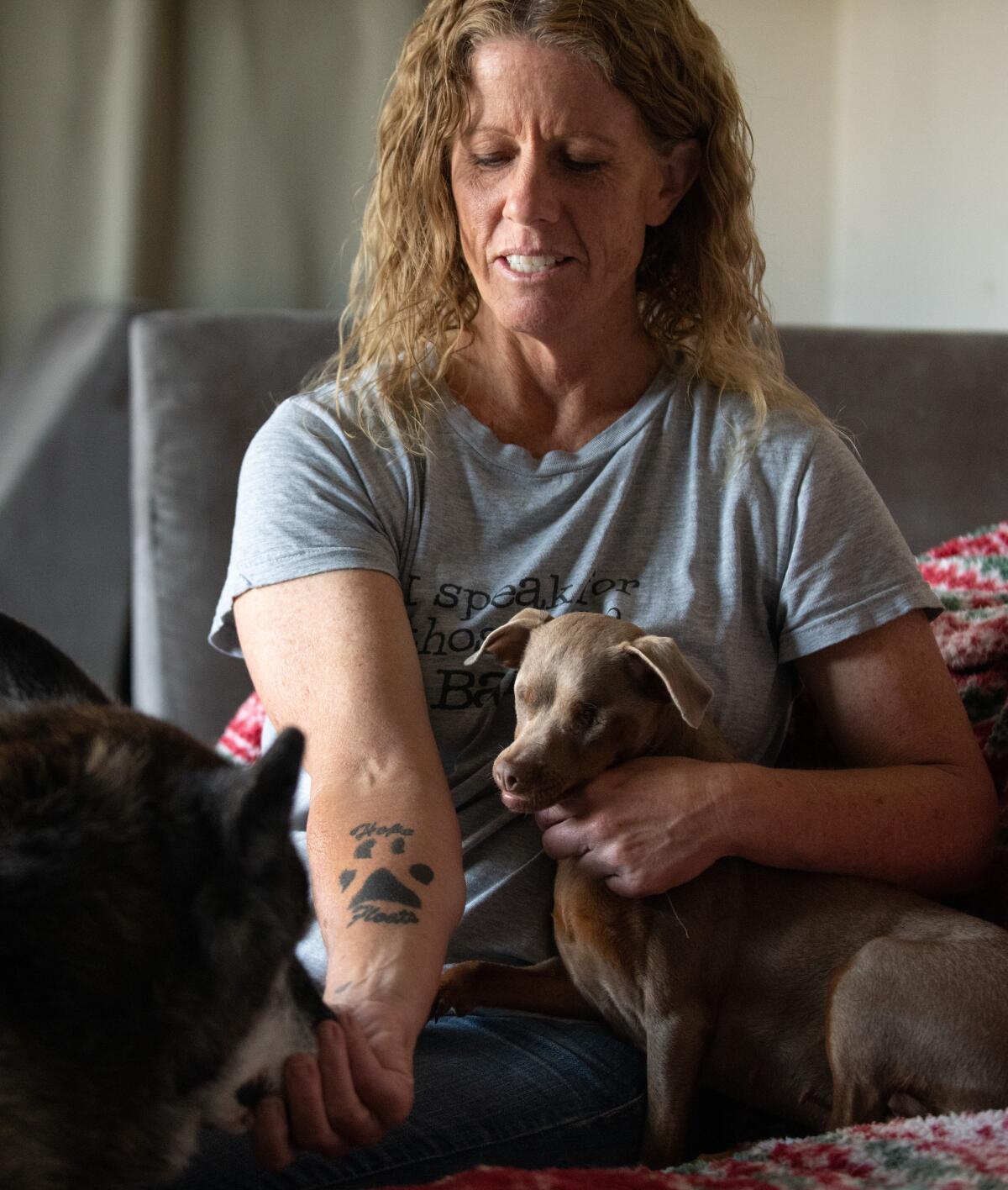 Karla Boss cuddles with pups at her home in Westminster where she fosters hard-to-adopt dogs on Thursday.