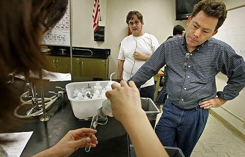 Chemistry students Dram Pham and Kevin Fulmer prepare for a test with Santa Ana College professor Jeff McMillan. McMillan and about a dozen faculty and staff at Santa Ana College have started a scholarship fund that they hope will make it easier for low-income students to afford their classes.