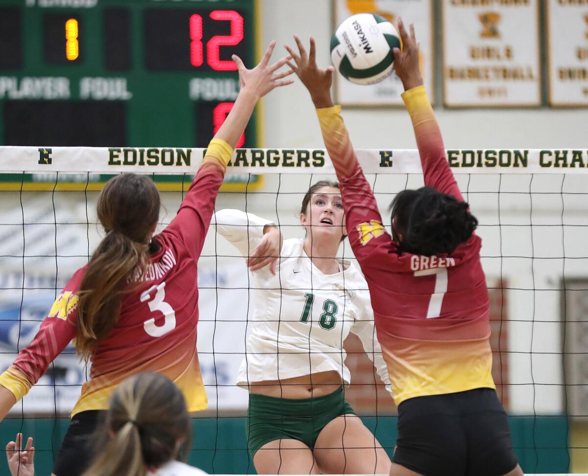 Edison's Morgan Gillinger (18) hits a quick set between two blockers during the CIF Division 3 quarterfinals against Wilson.