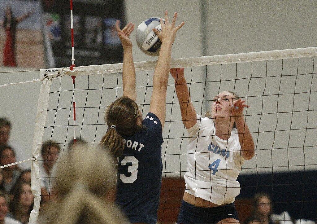 Corona del Mar High's Jessie Harris (4) hits into Newport Harbor's Carolyn Bockrath during the Battle of the Bay girls' volleyball match on Saturday.