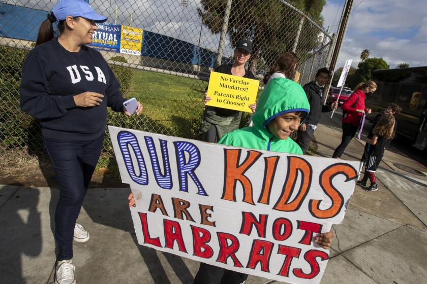 ENCINO, CA - October 18 2021: Parents and students from around the San Fernando Valley hold signs and shout as a protest against vaccine mandates in front of Birmingham High School on Monday, Oct. 18, 2021 in Encino, CA. (Brian van der Brug / Los Angeles Times)