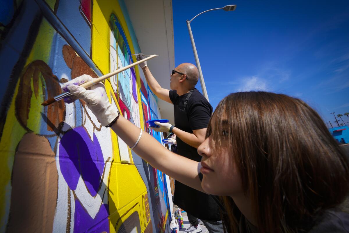 Leona Martinez, 14 and Mike Encarnacion were among a group who took part in a community effort to revitalize Broadway.