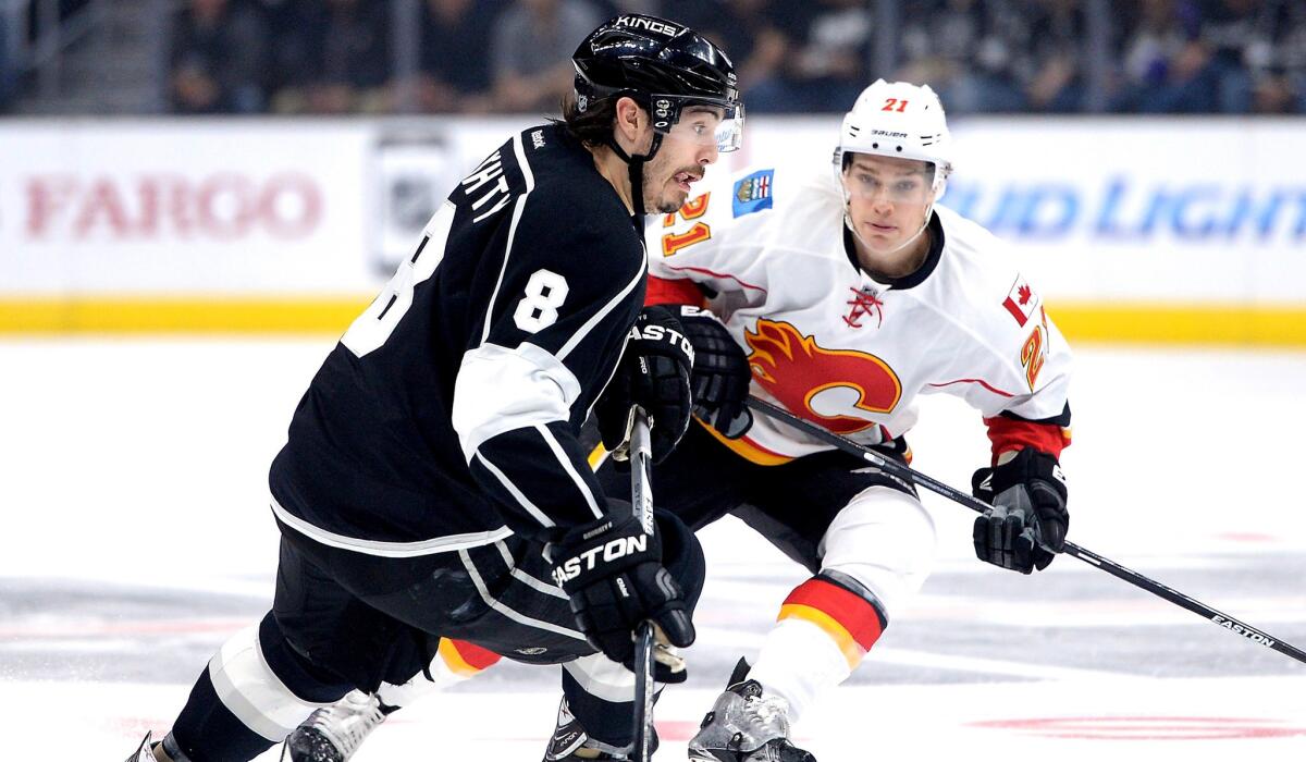 Kings defenseman Drew Doughty brings the puck up ice against Flames center Mason Raymond in the first period during their game Monday night.