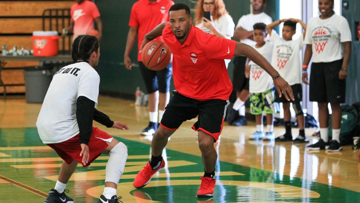 Norman Powell drives the ball downcourt while playing a game with young players during the second annual Norman Powell Youth Basketball Camp at Lincoln High.