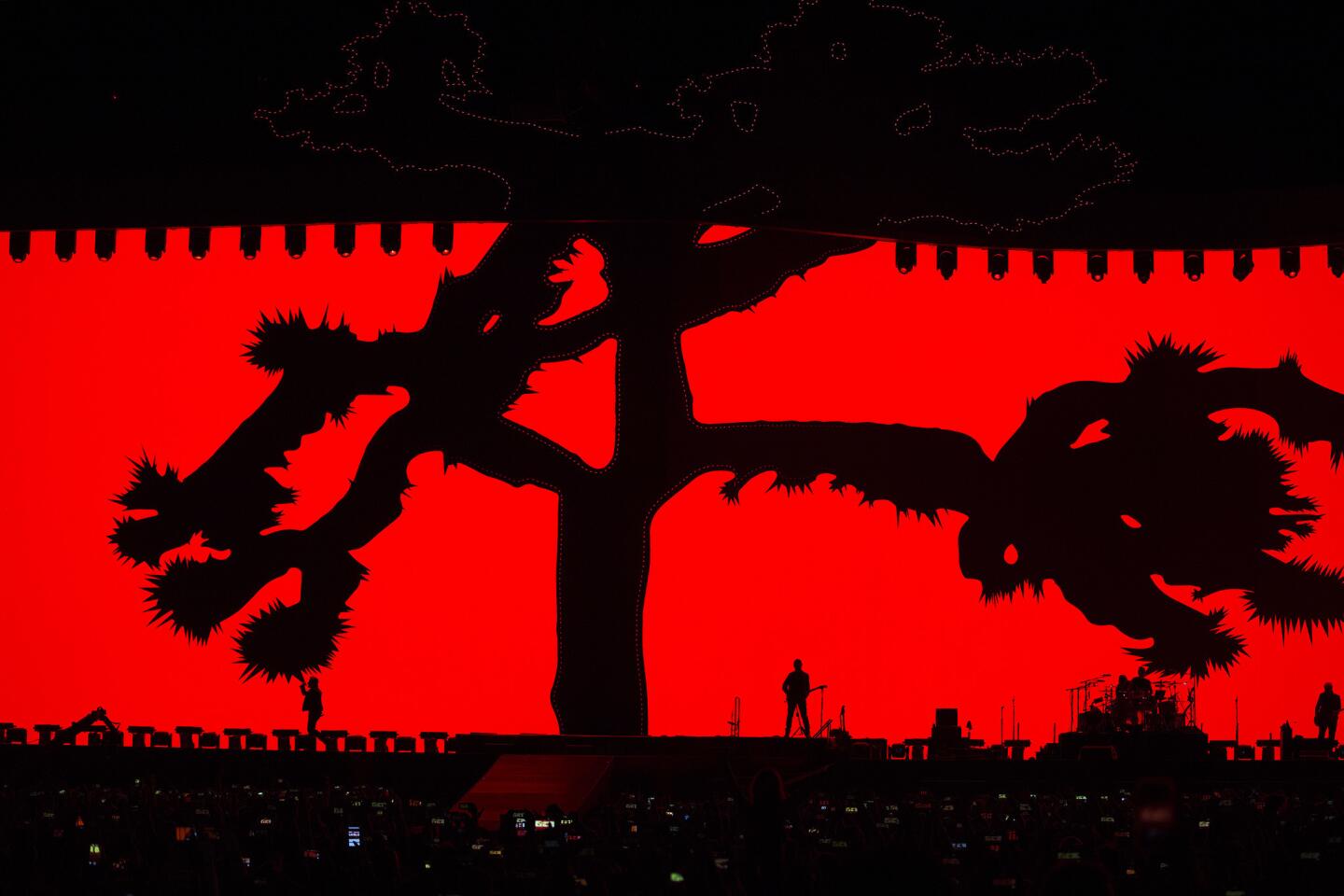 Silhouetted against a giant backdrop, U2 performs its "Joshua Tree" anniversary tour at the Rose Bowl on Saturday.