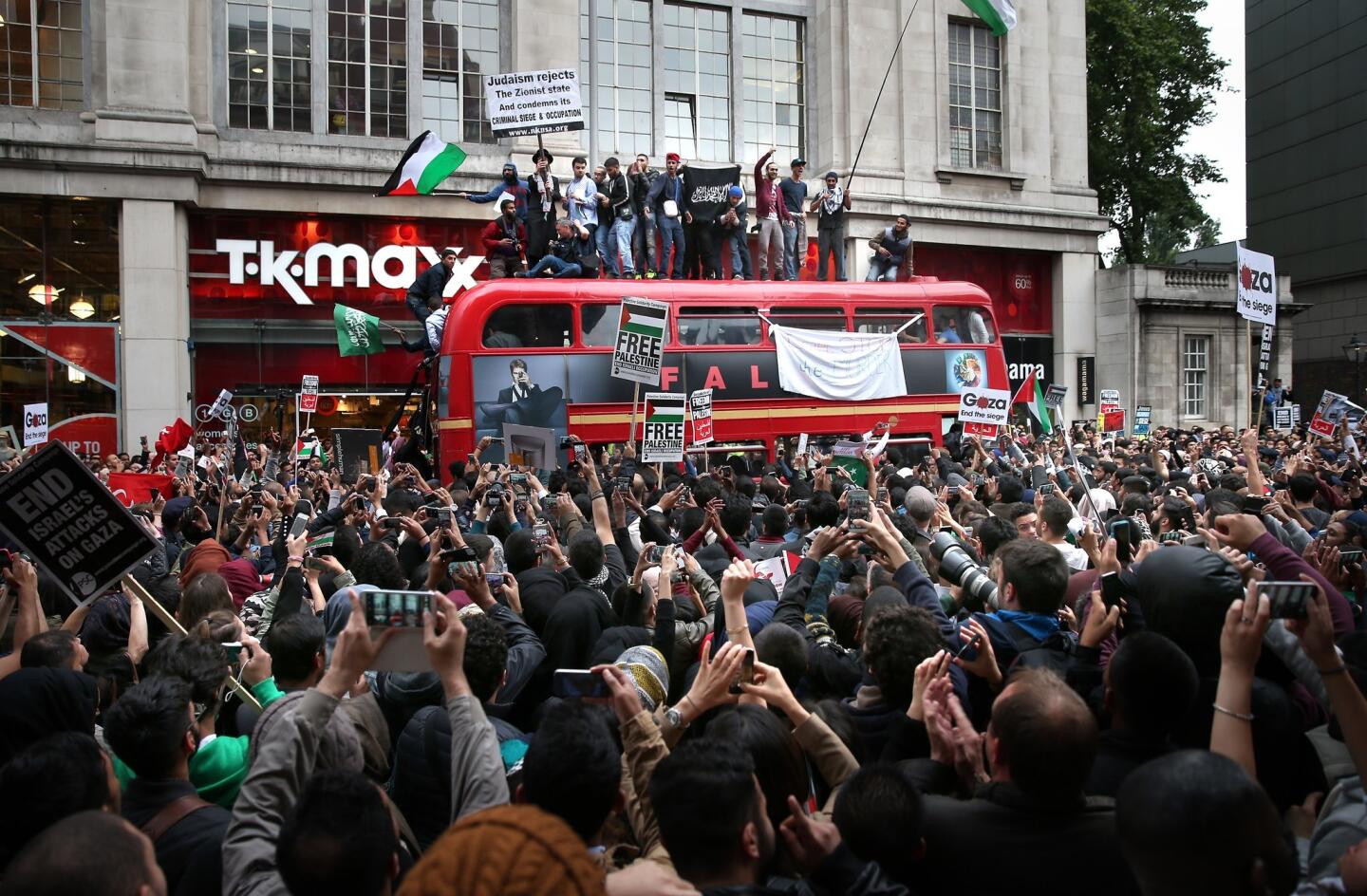 Pro-Palestinian demonstrators occupy a London bus and fill the street outside the Israeli Embassy in London on July 11.