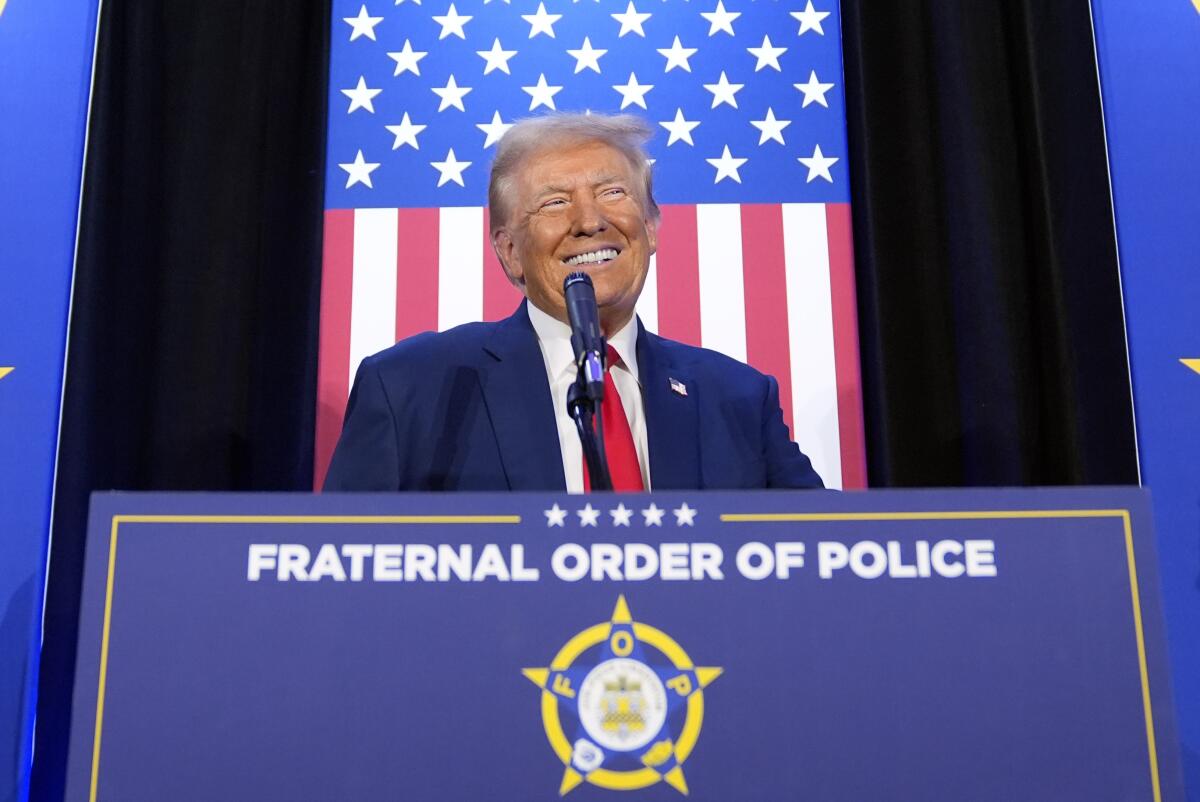 Donald Trump speaks at a lectern with a a logo below the words "Fraternal Order of Police"