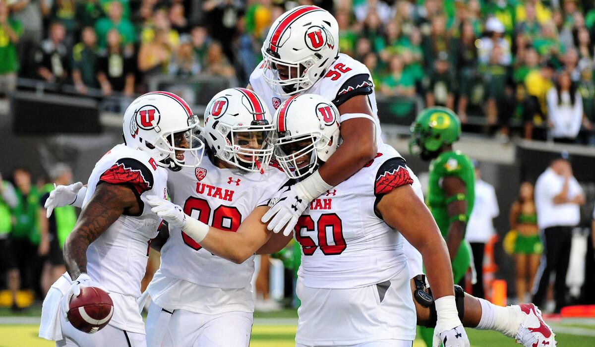 Utah's wide receiver Kenneth Scott, far left, celebrates with teammates after scoring a touchdown in the second quarter against Oregon on Saturday.