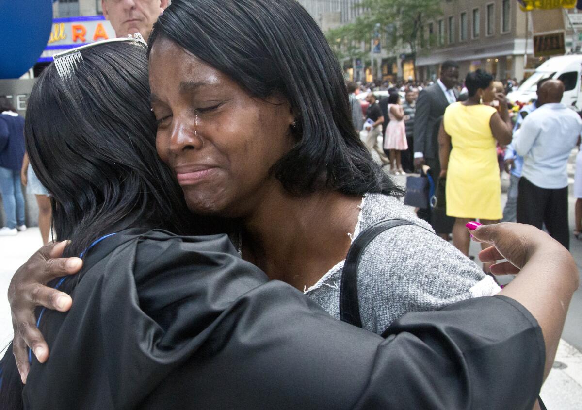 En esta imagen, tomada el 9 de junio de2015, Candie Hailey (derecha), llora mientras abraza a su hermana Chyna tras su graduación universitaria en Nueva York. Candie pasó dos años y un tercio en aislamiento en el penal de Rikers. (Foto AP /Bebeto Matthews)