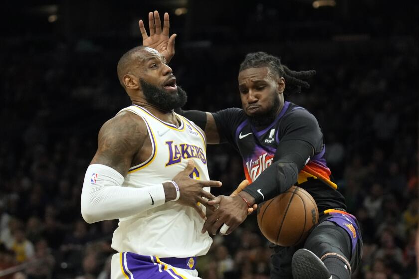 Phoenix Suns forward Jae Crowder, right, strips the ball from Los Angeles Lakers forward LeBron James during the first half of an NBA basketball game, Sunday, March 13, 2022, in Phoenix. (AP Photo/Rick Scuteri)
