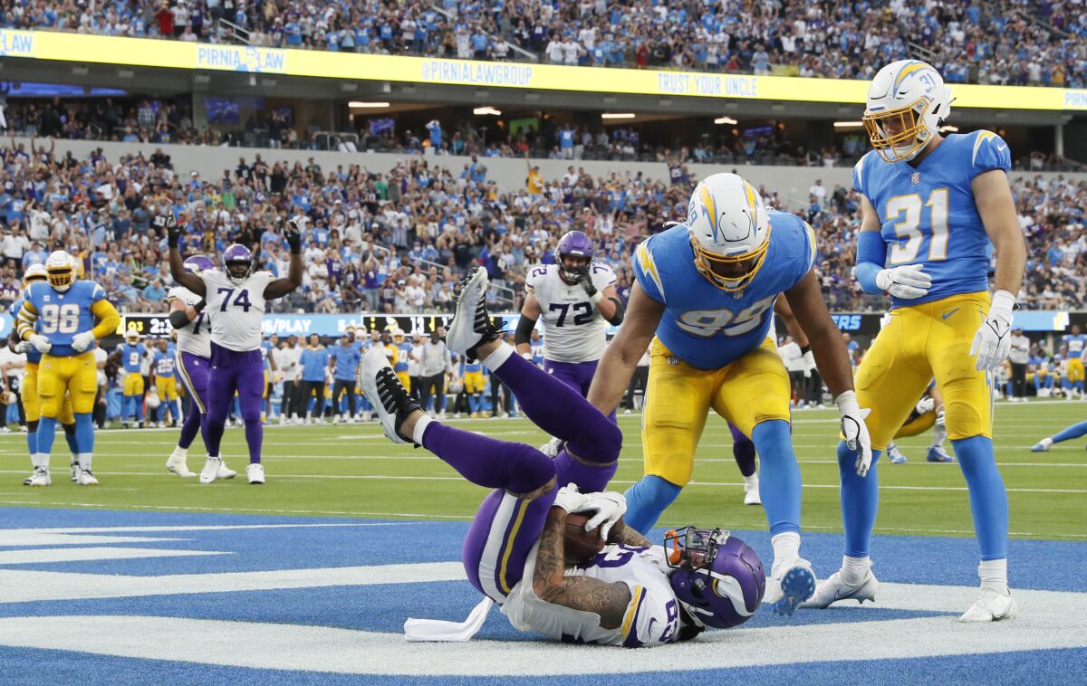 Vikings tight end Tyler Conklin catches a touchdown pass as Chargers Jerry Tillery (99) and Nick Niermann arrive too late.