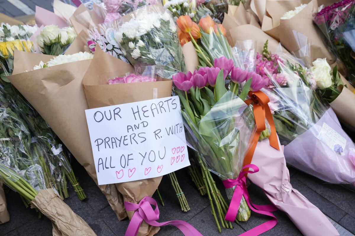 A note is left with flower tributes near a crime scene.