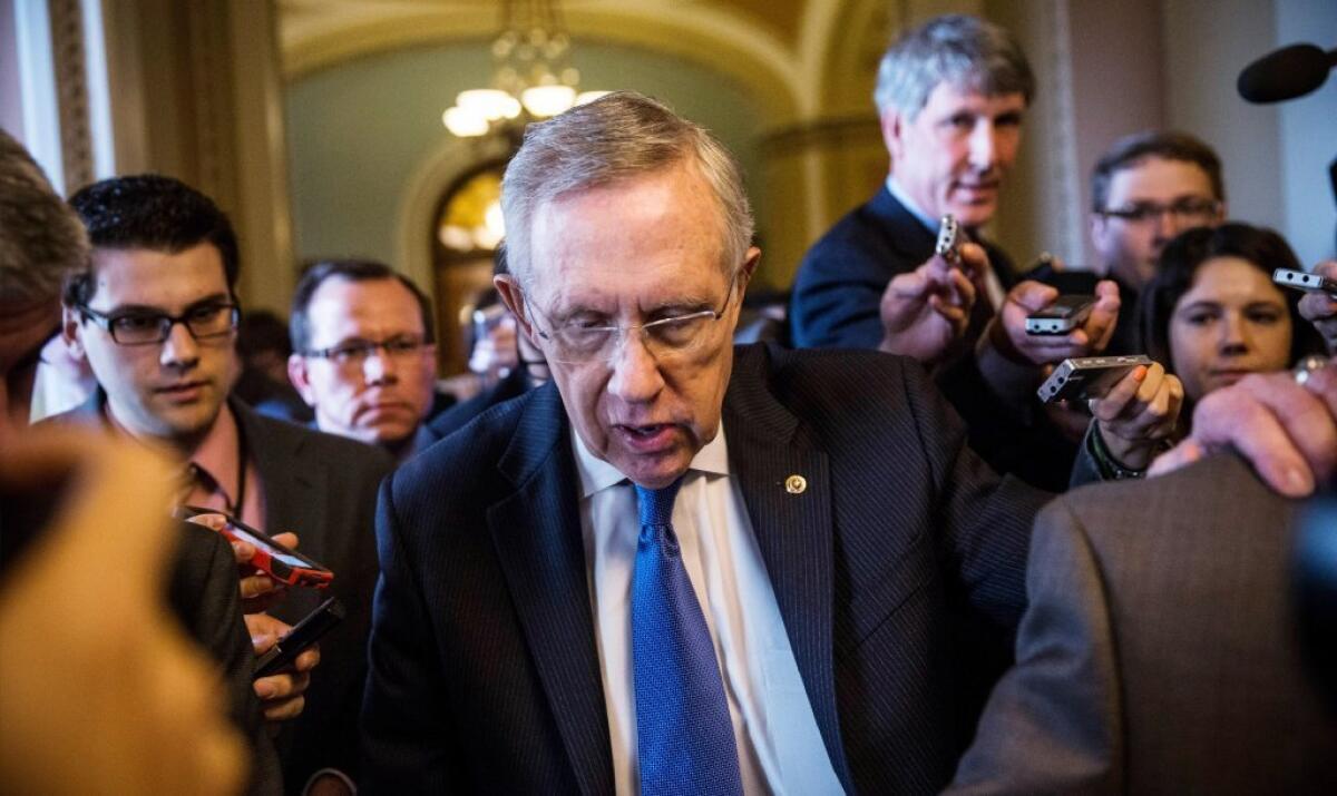 Surrounded by reporters, Majority Leader Harry Reid walks through the halls of Senate.