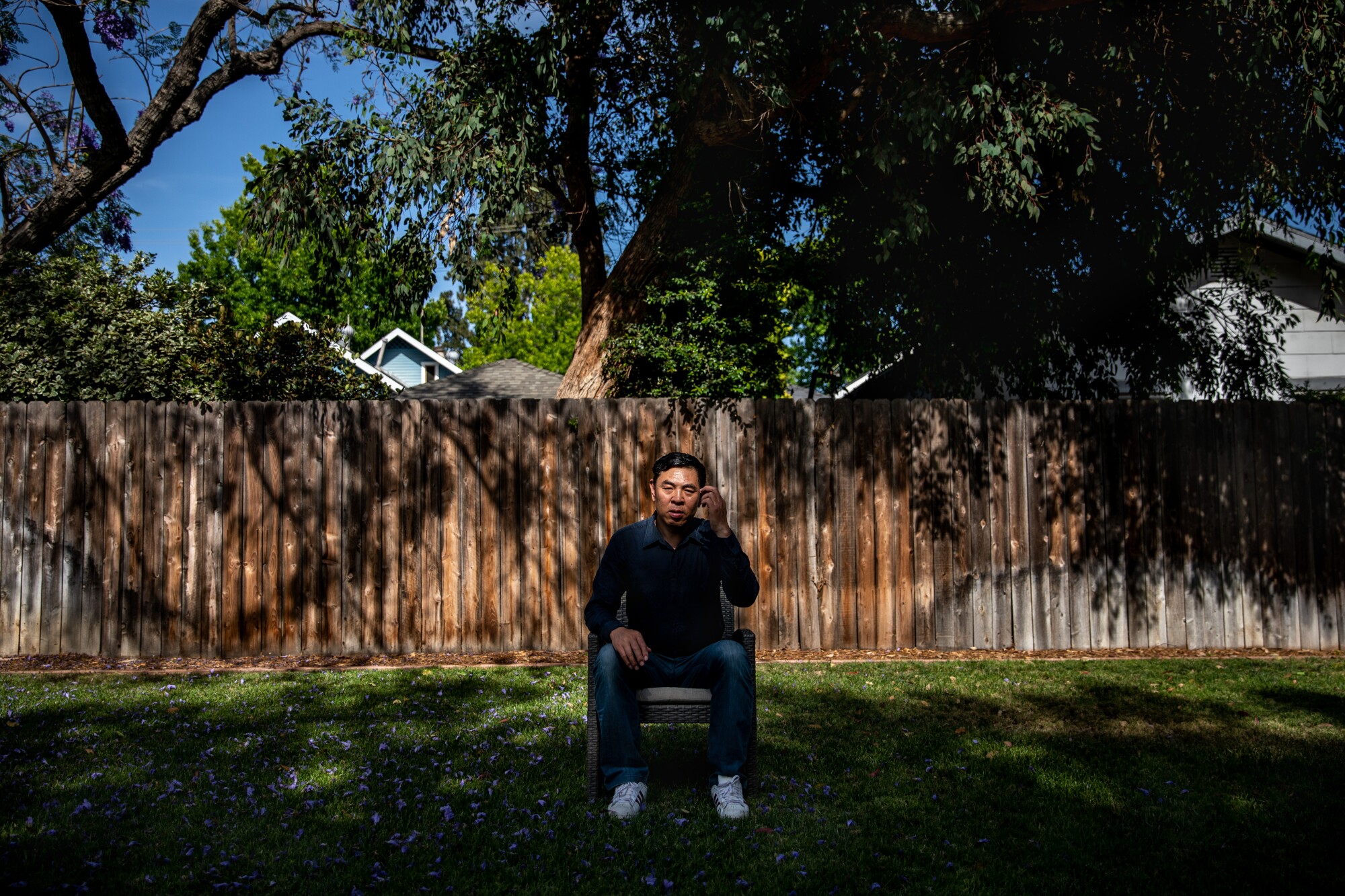 A man sits in a backyard.