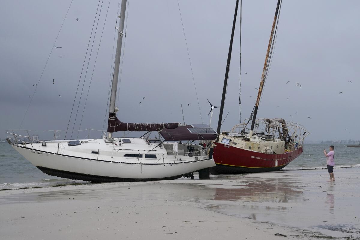 Boats sit on the beach in the aftermath of Tropical Storm Eta on Thursday in Gulfport, Fla.